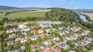 Luftaufnahme, die eine Siedlung mit vielen Häusern mit Solarmodulen auf dem Dach zeigt