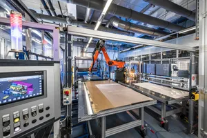 At the center of the demonstration line for the flexible, highly automated production of PV modules is a robot arm.