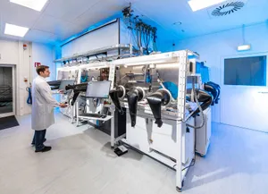 Ein Labormitarbeiter steht an einer Maschine zur Perowskit-Dünnschichtherstellung