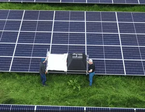 Zwei Personen bedienen ein mobiles Prüfgerät zur Messung von Photovoltaikmodulen auf einem Freifeld-Testfeld am ISFH.