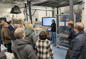 Lara Bakker erklärt im ISFH-Labor den automatisierten Lötprozess für silberfreie Solarzellen.